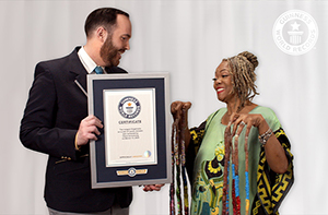 woman with longest fingernails being awarded gwr certificate by adjudicator