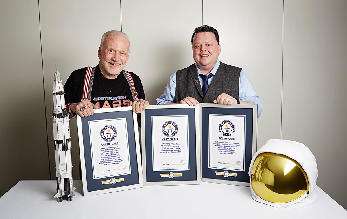 Buzz aldrin and Craig Glenday posing next to GWR certificates