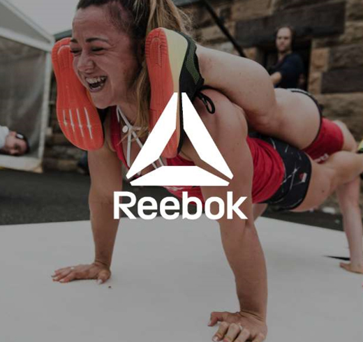 reebok logo on top of image of woman doing plank on top of another woman